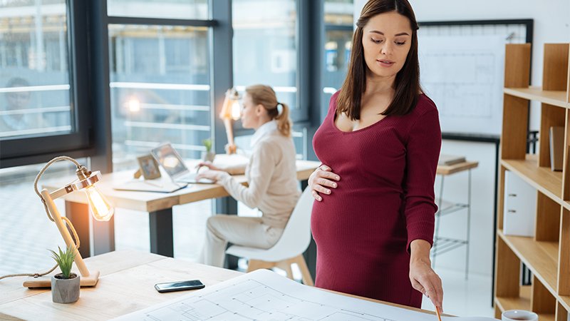 Gravid dame på kontoret sammen med en kollega.