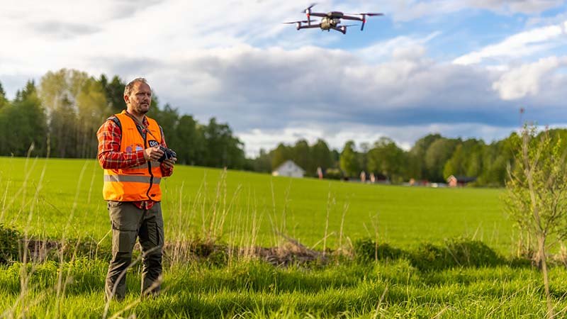 Bonde med drone i åker.