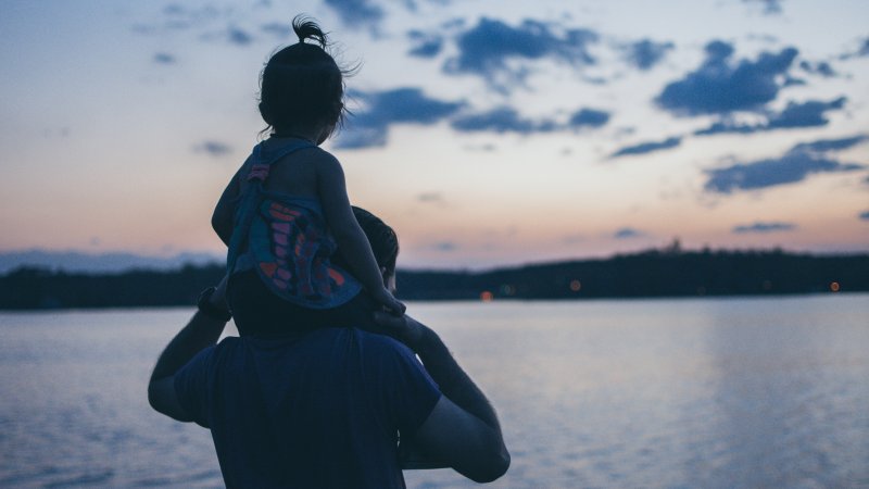 Bilde av tilfeldig far og datter som ser ut over havet