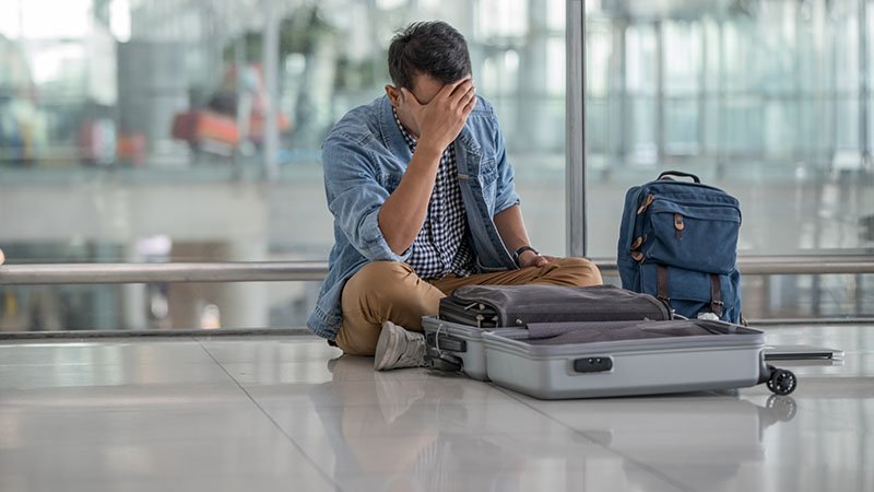 Fortvilet mann leter i bagasjen på flyplass