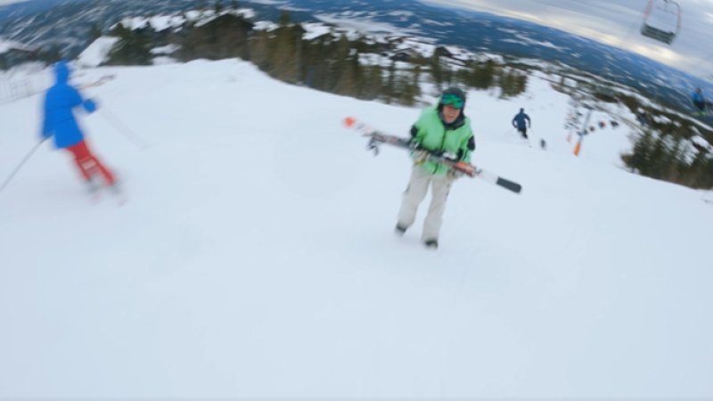 Filmen viser en gående som beveger seg oppover i skibakken samtidig som andre kommer kjørende ned på ski.